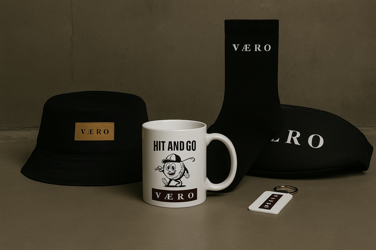 “VAERO accessories collection including bucket hat, waist bag, keychain and branded mug displayed on a neutral studio background.”