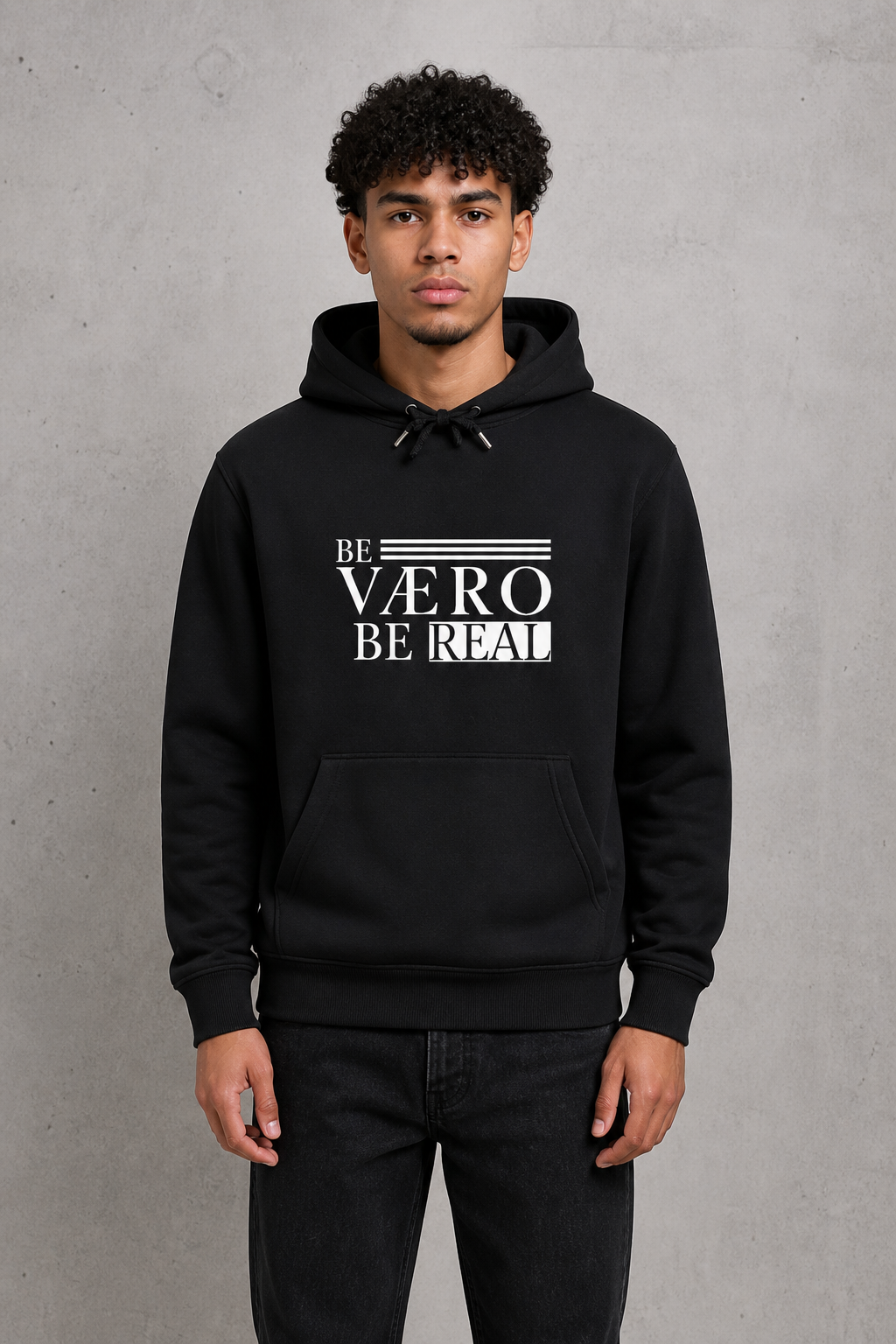 Person wearing a black hoodie with 'BE VERO BE REAL' text on a gray background