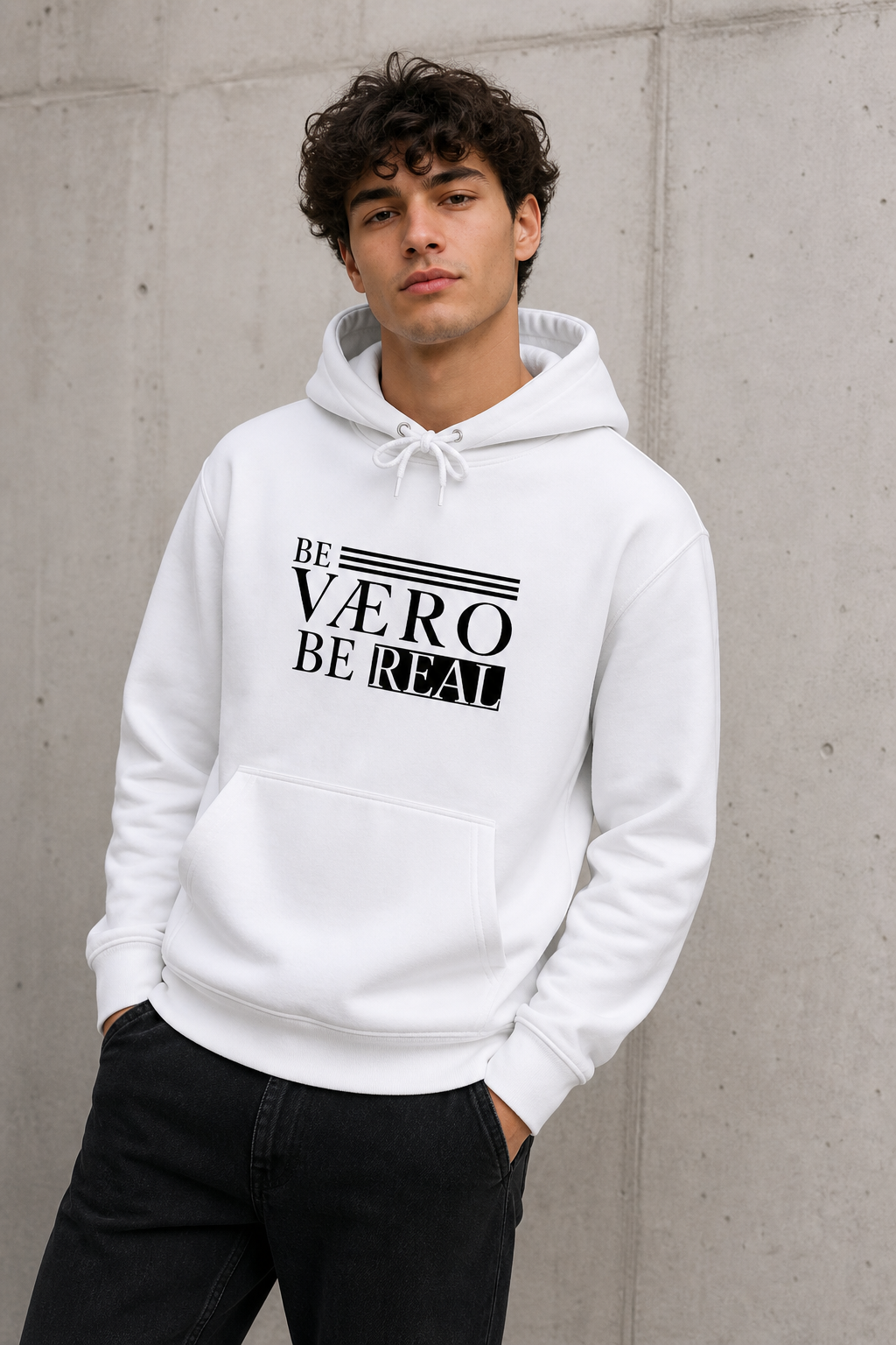 Person wearing a white hoodie with text against a concrete wall