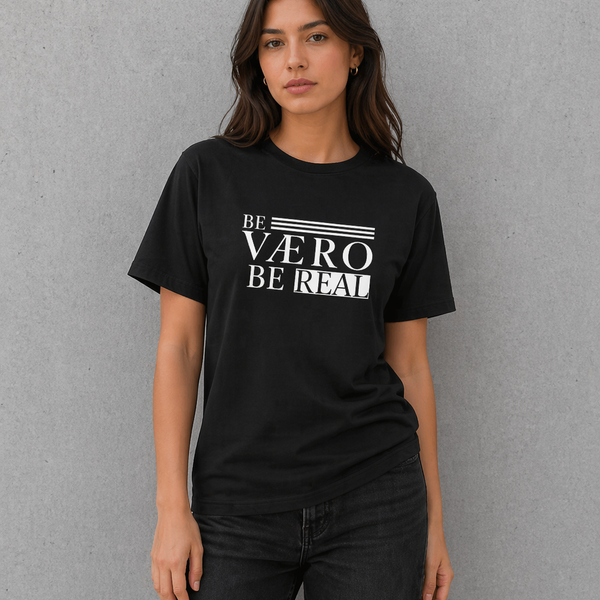 Woman wearing a black t-shirt with 'BE VAERO BE REAL' text on a gray background