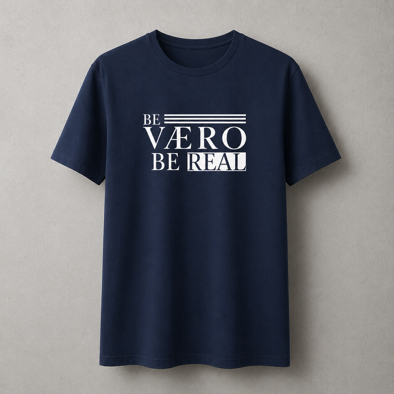 Navy blue t-shirt with white text 'BE VAERO BE REAL' on a gray background