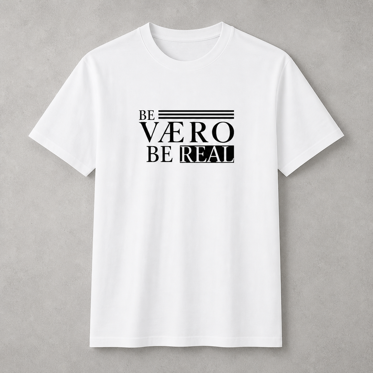 White t-shirt with black text 'BE VØERO BE REAL' on a gray background