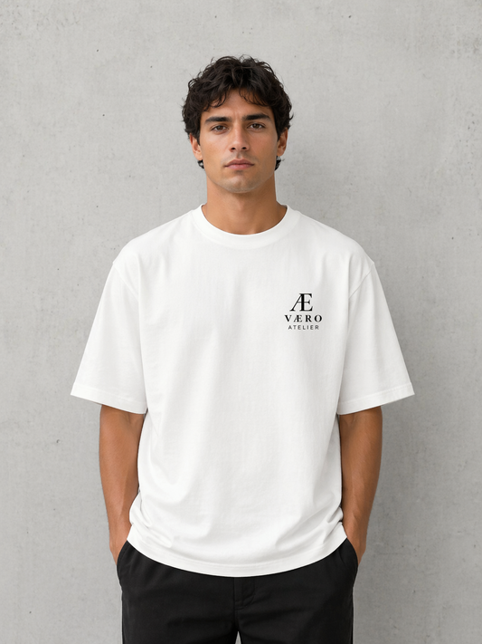 Man wearing a white t-shirt with a logo on a gray background
