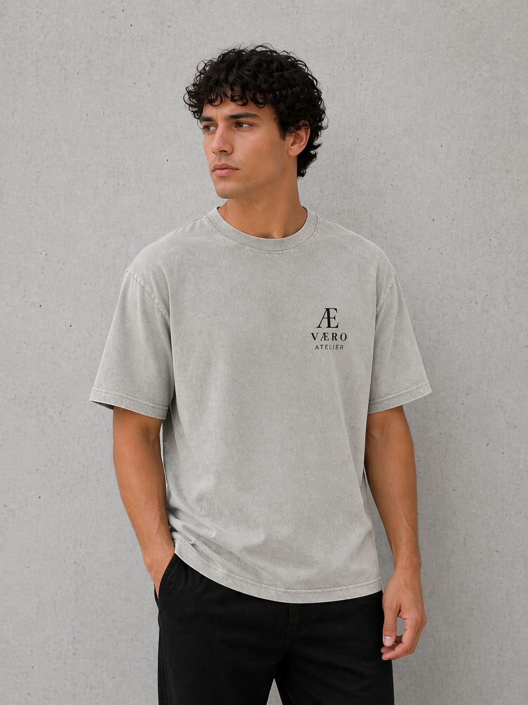Man wearing a gray t-shirt with a logo against a plain background