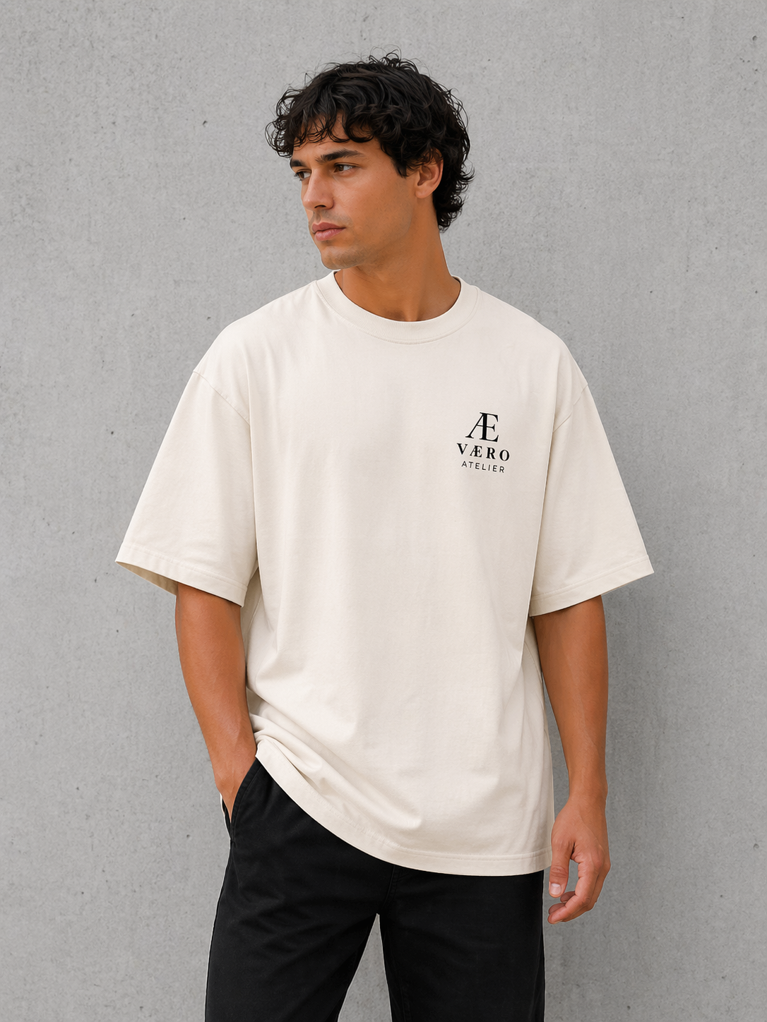 Man wearing a beige t-shirt with a logo against a gray background
