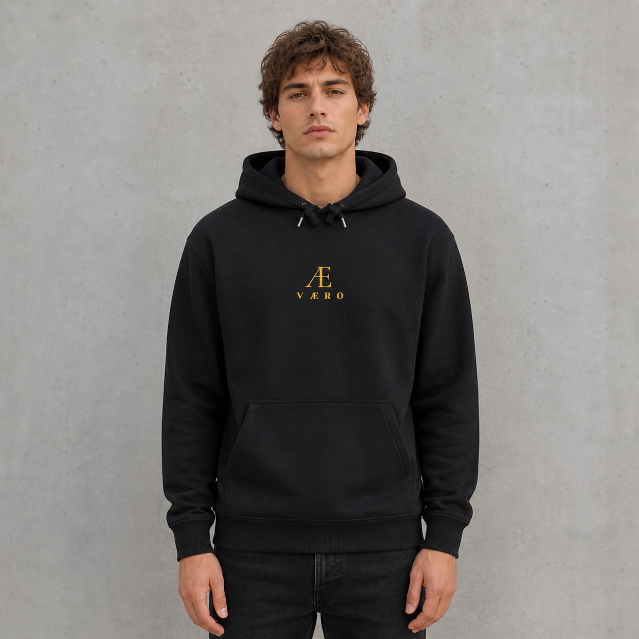 Person wearing a black hoodie with a logo on a gray background