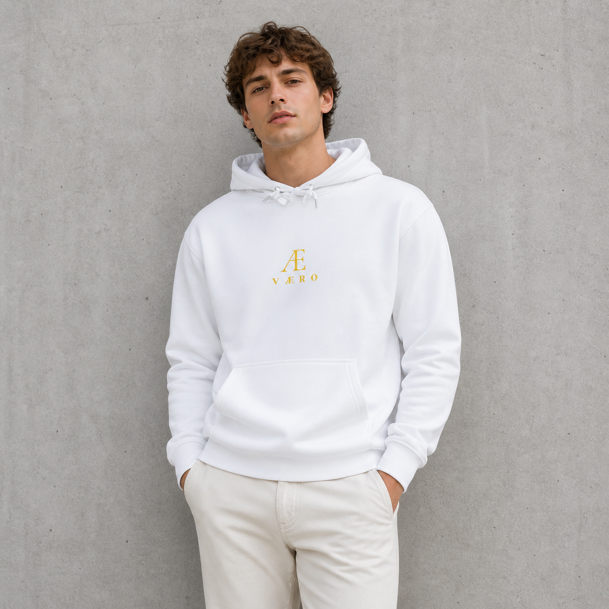 Man wearing a white hoodie with a logo against a gray background