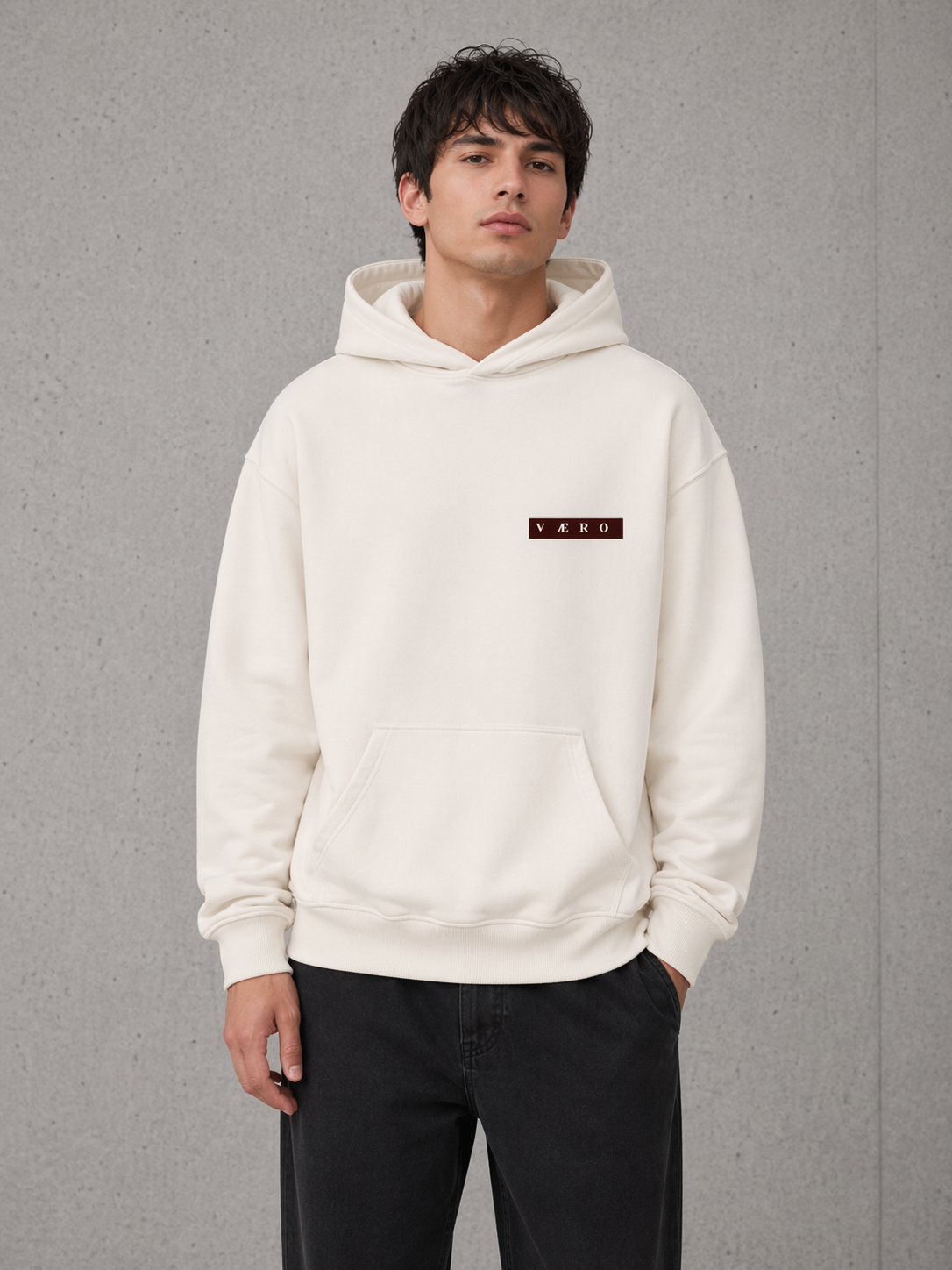 Person wearing a white hoodie with a brand logo on a gray background