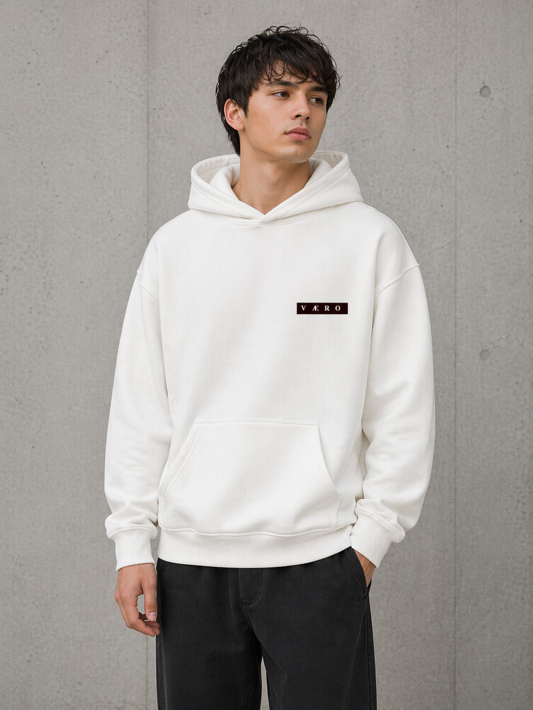 Person wearing a white hoodie with a logo on a gray background