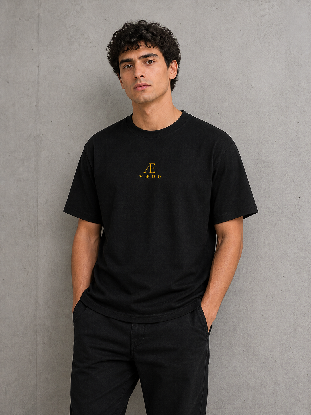 Man wearing a black t-shirt with a logo against a gray background