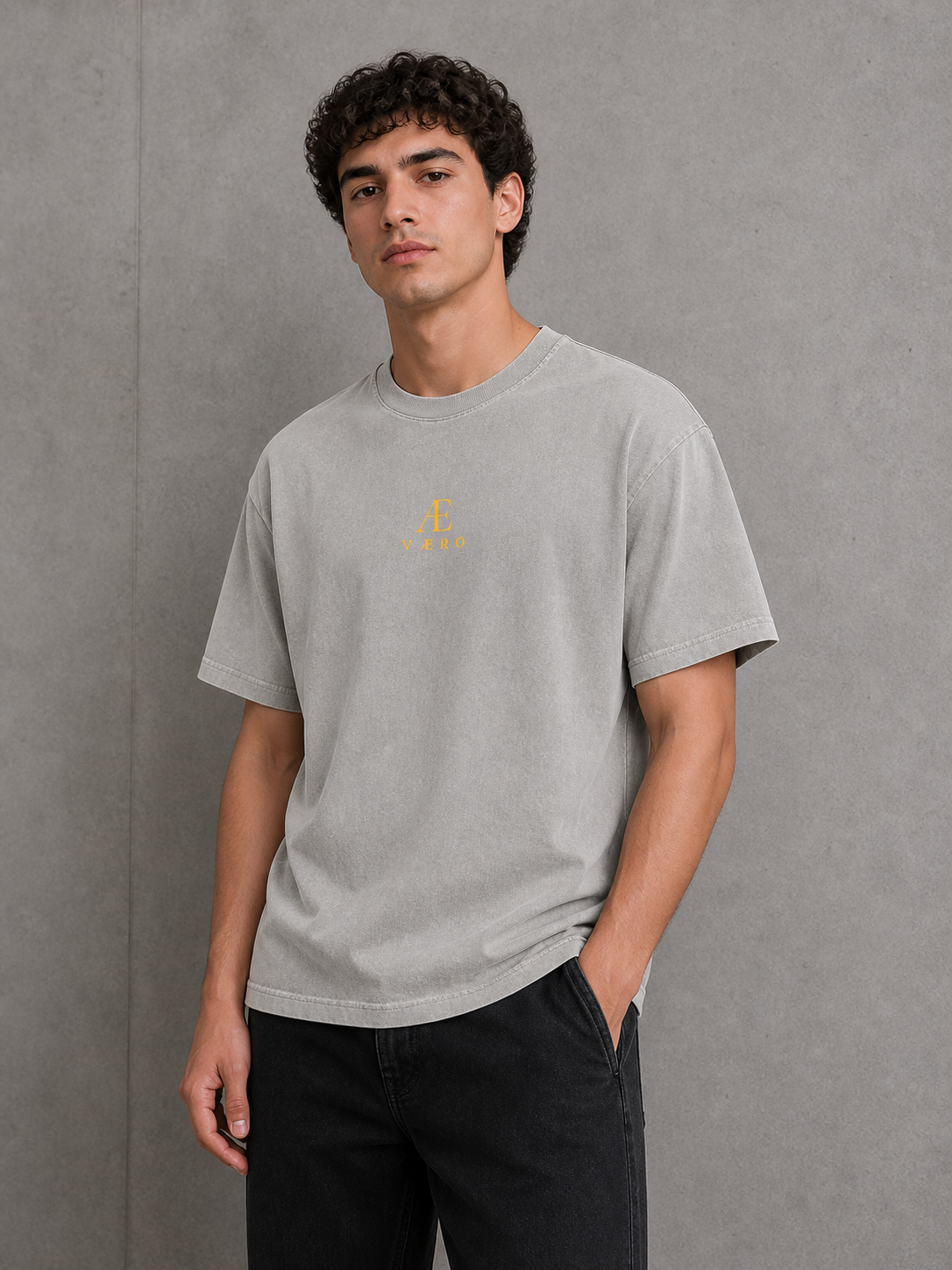 Man wearing a gray t-shirt with a logo against a gray background