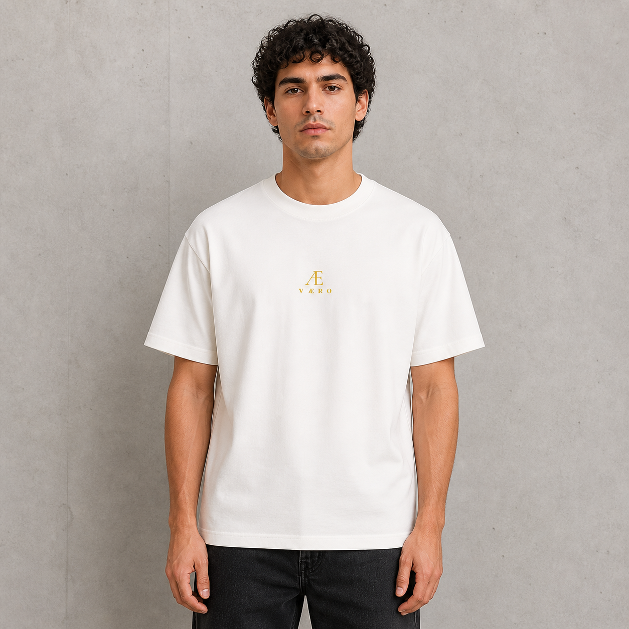 Man wearing a white t-shirt with a small logo on a gray background
