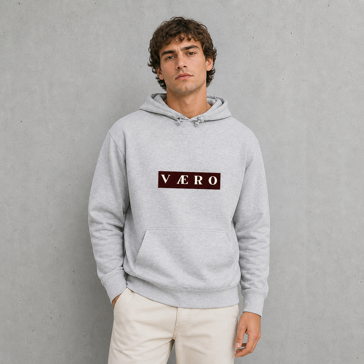 Man wearing a gray hoodie with 'VAERO' logo against a gray background