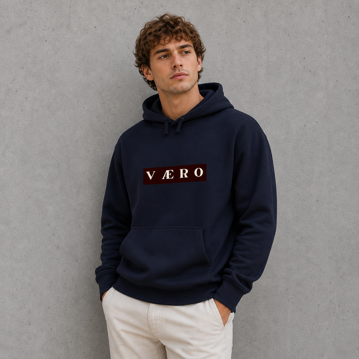 Man wearing a navy hoodie with 'VAERO' logo against a gray background