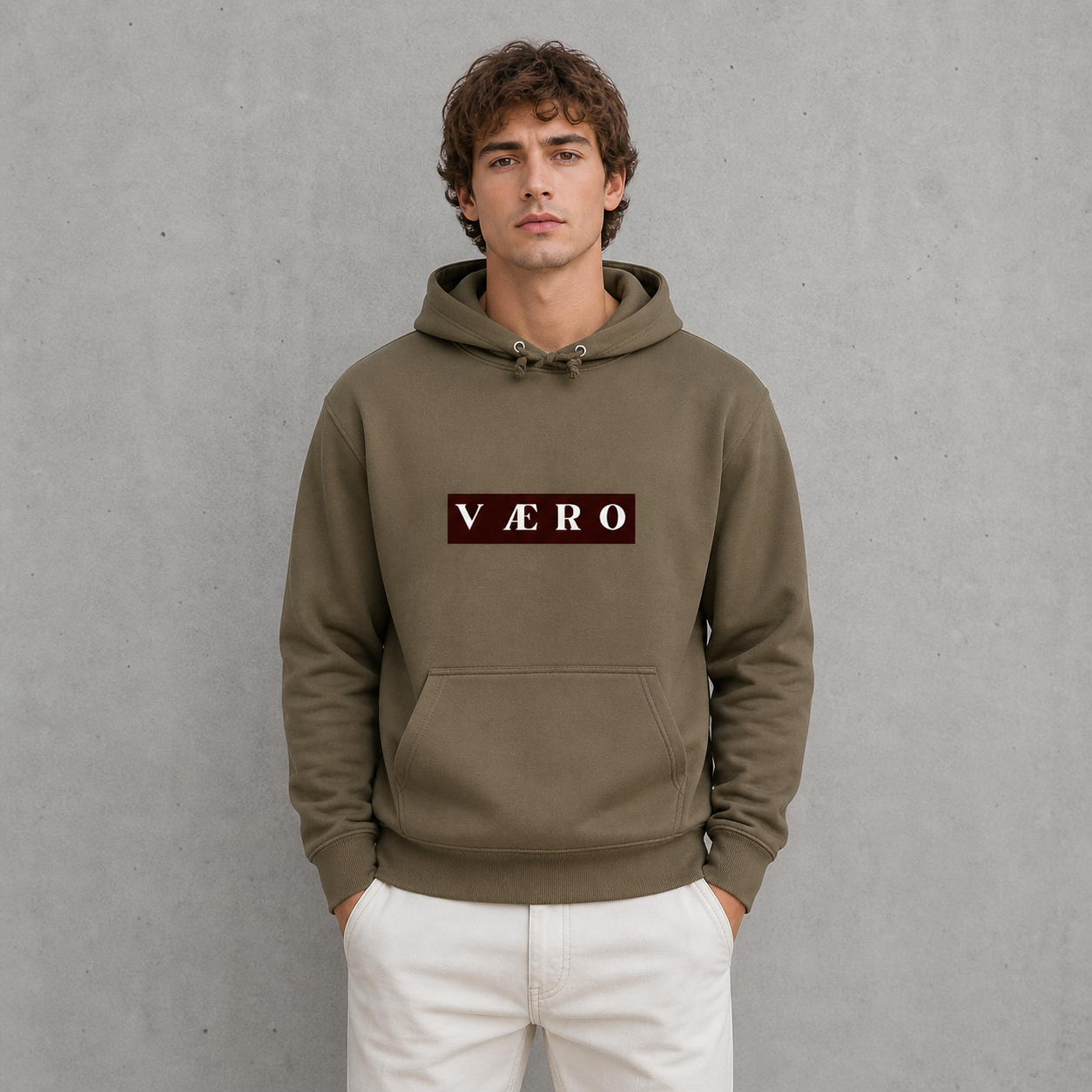 Man wearing a brown hoodie with 'VAERO' logo against a gray background