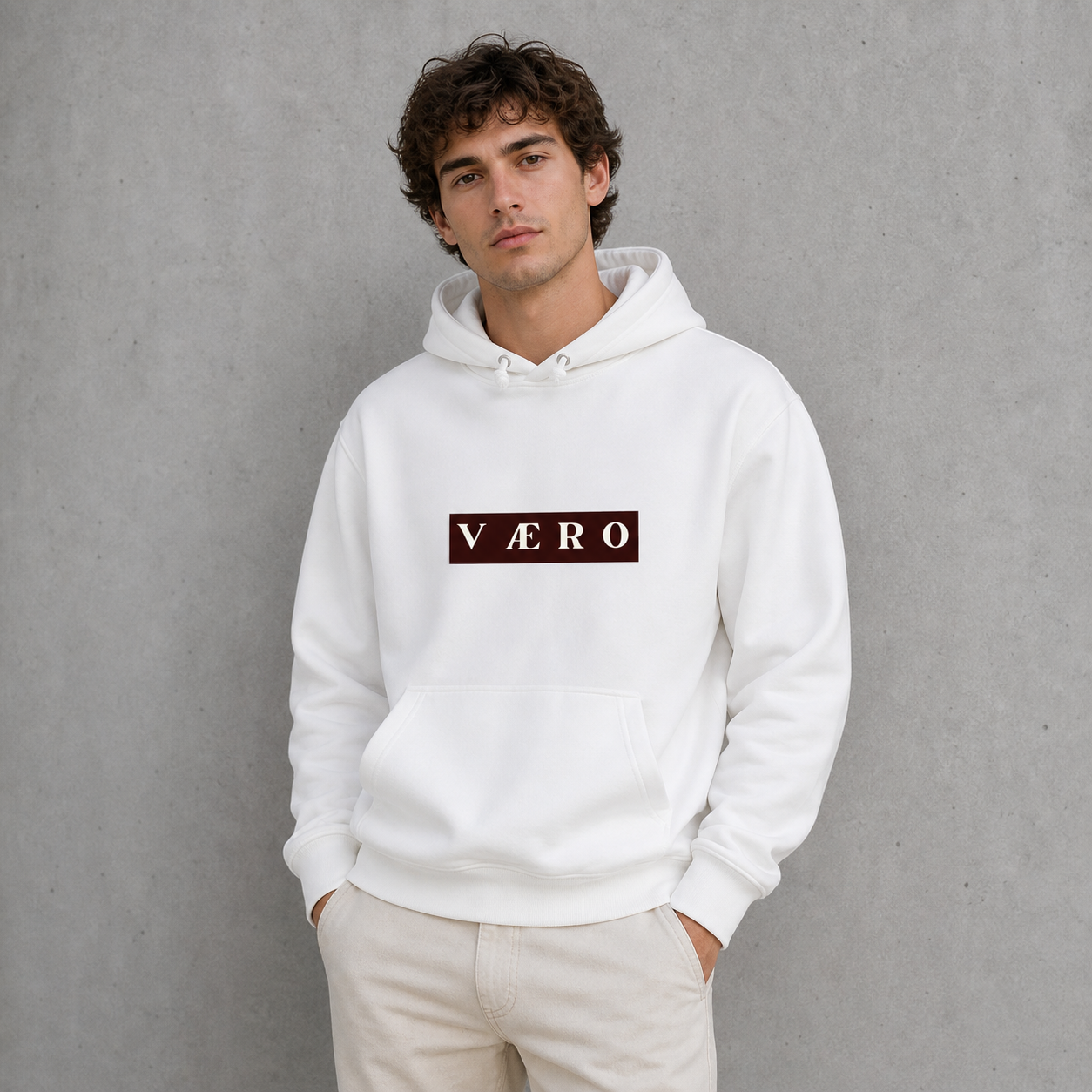 Person wearing a white hoodie with a logo on a gray background