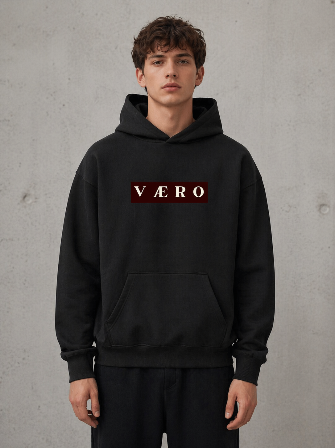 Person wearing a black hoodie with 'Väro' logo on a gray background