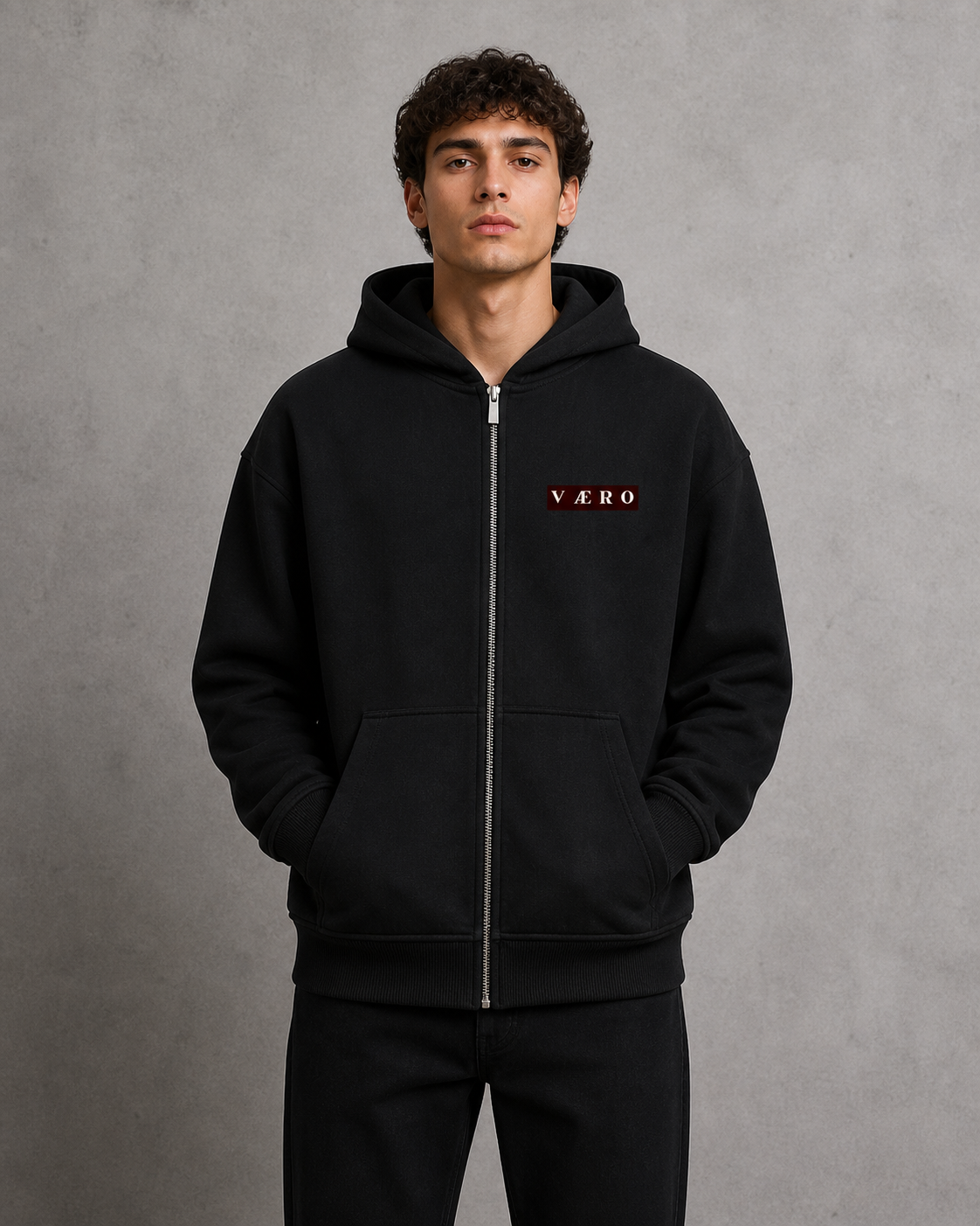 Person wearing a black hoodie with 'VAERO' branding on a gray background