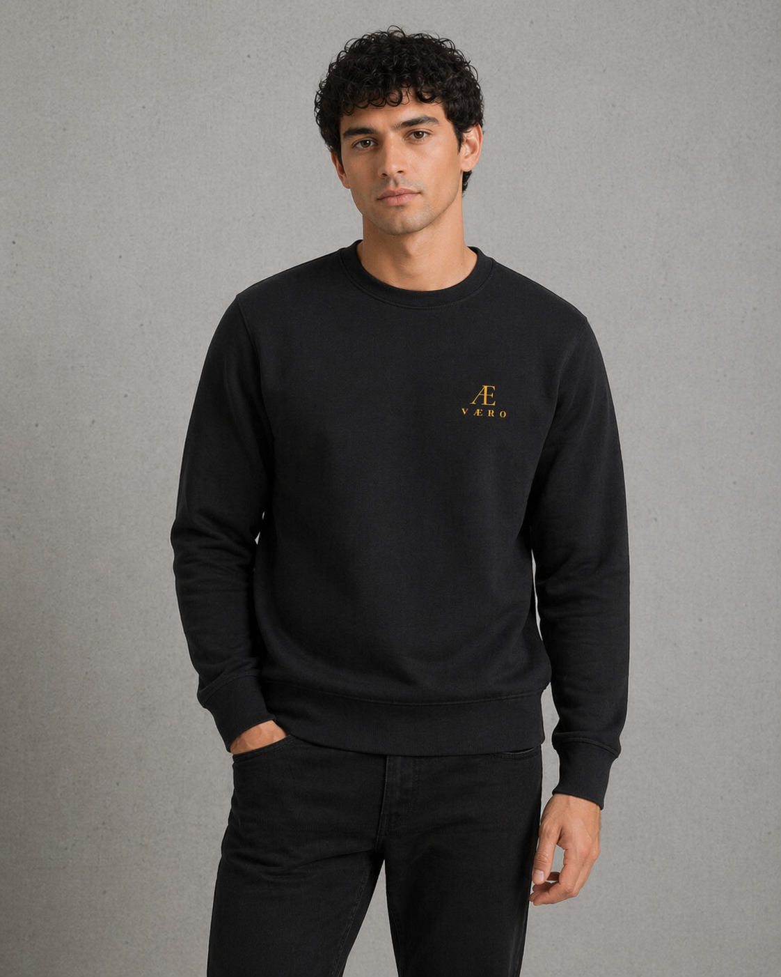 Man wearing a black sweatshirt with a logo on a gray background