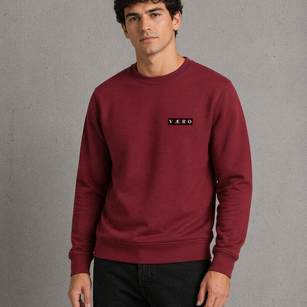 Man wearing a maroon sweatshirt with a logo on a gray background