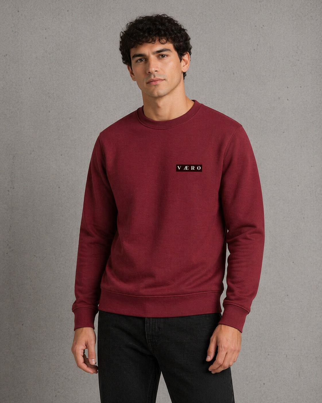 Man wearing a maroon sweatshirt with a logo on a gray background