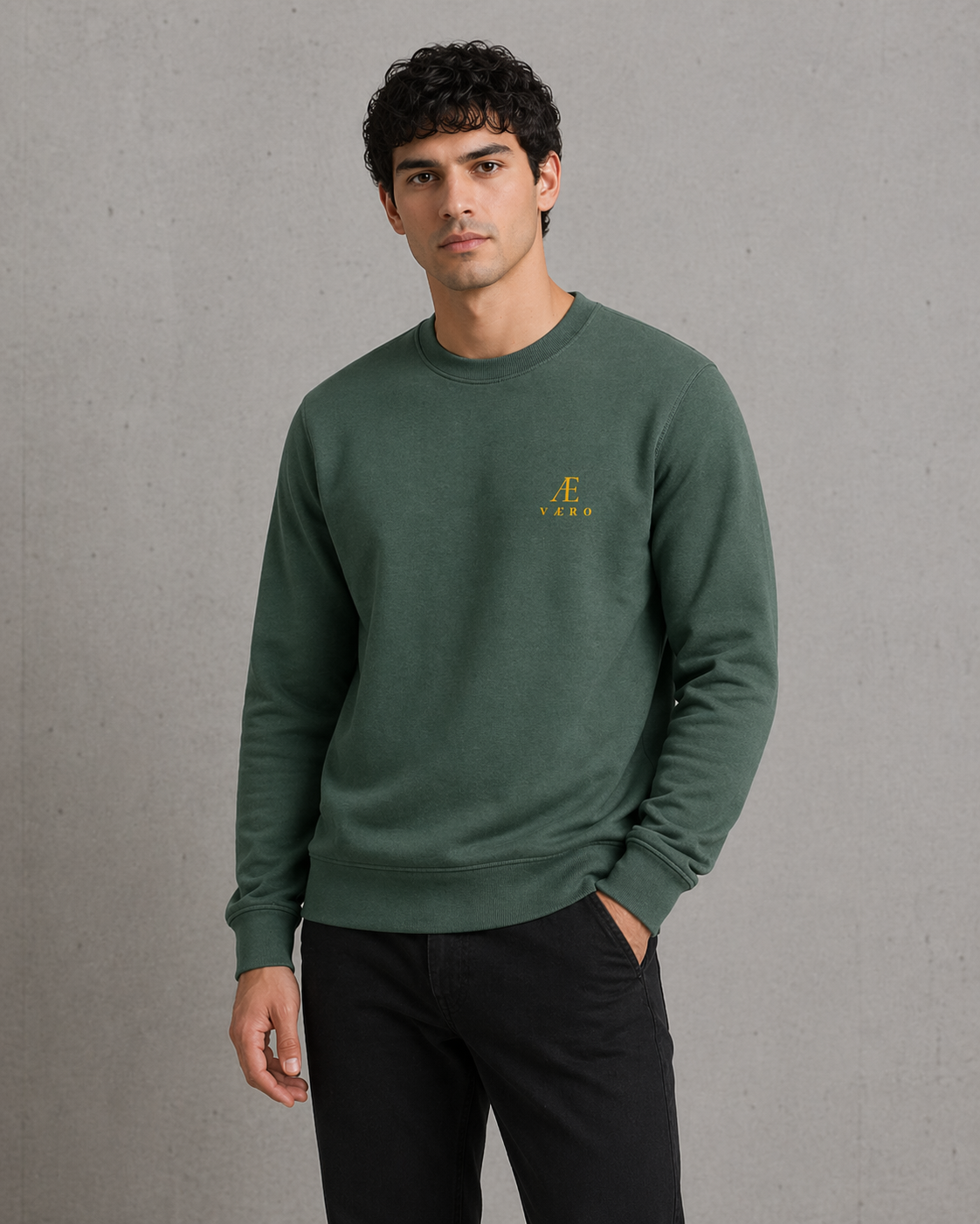 Man wearing a green sweatshirt with a logo on a gray background