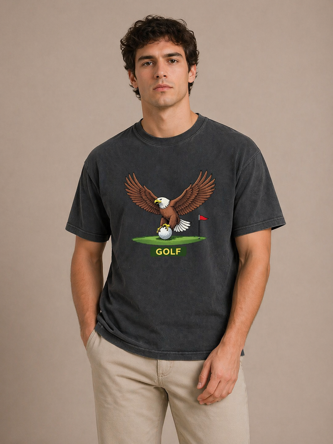 Man wearing a black t-shirt with an eagle and golf ball graphic on a beige background