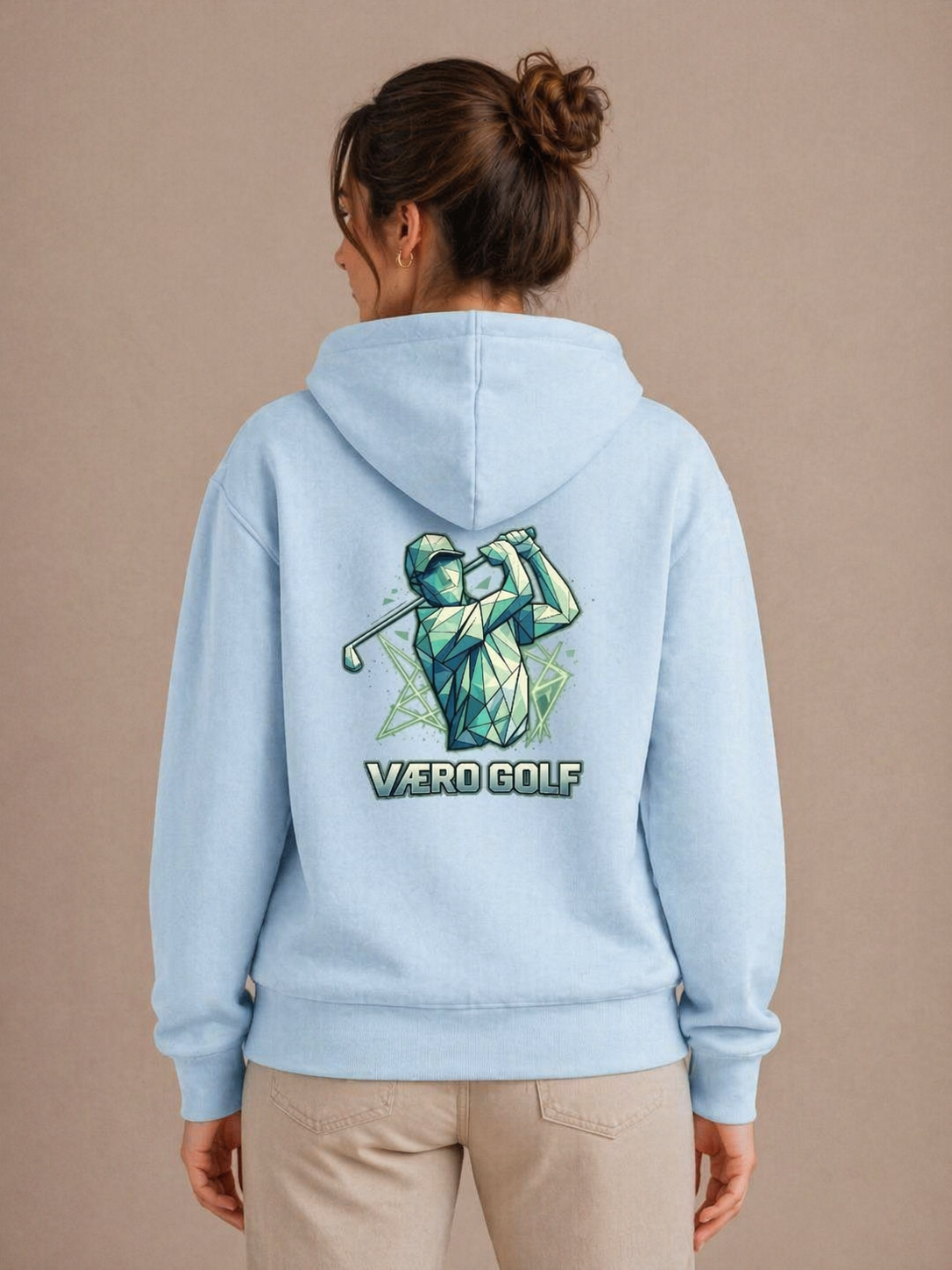Person wearing a light blue hoodie with a golf graphic and 'VERO GOLF' text on the back, against a beige background.